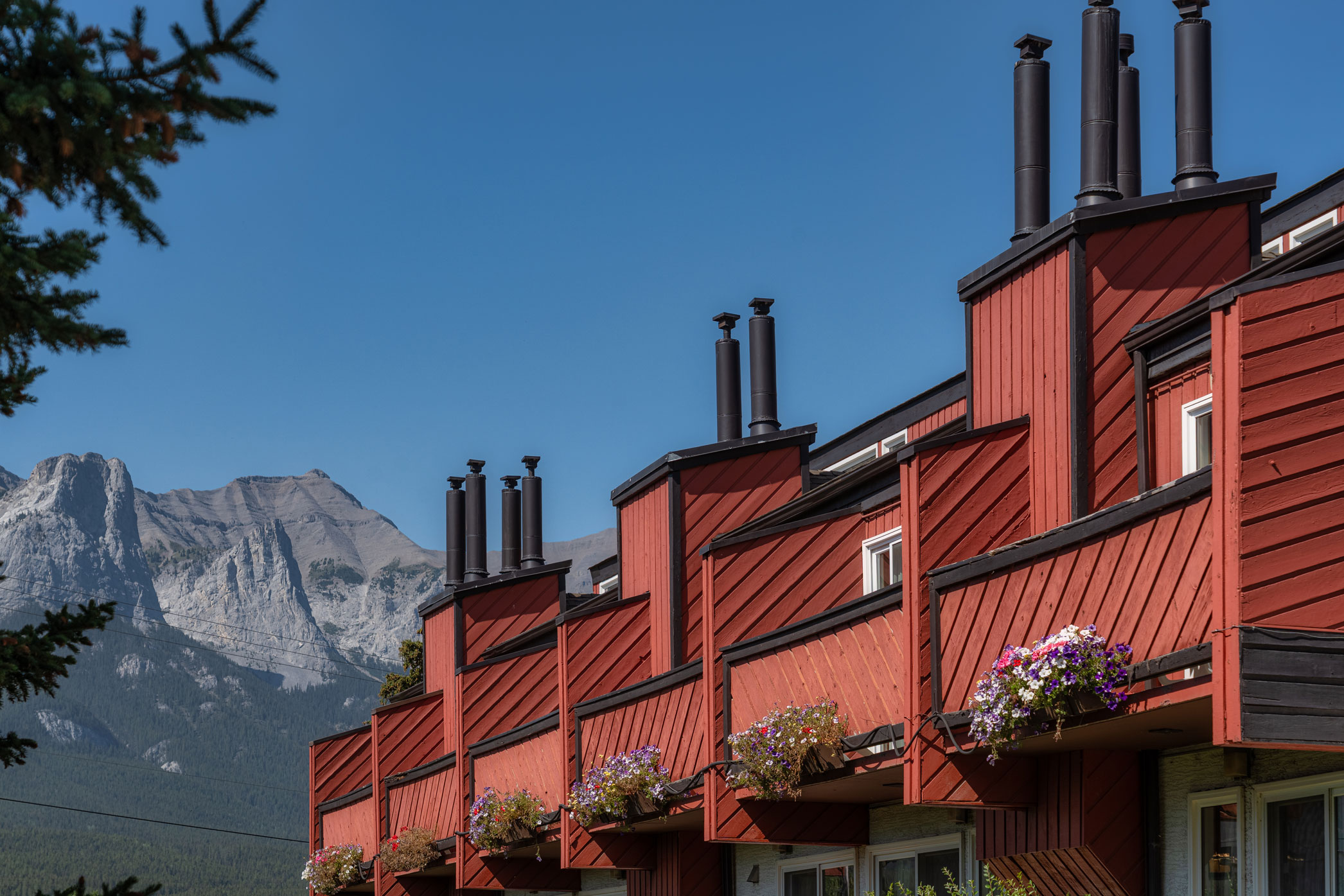 View of red balconies at the Rocky Mountain Ski Lodge in Canmore with a mountain backdrop
