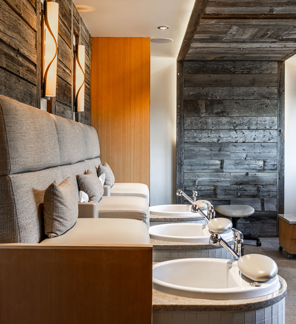 woman in otter hotel robe sitting poolside by the fire pits with mountain views in the winter