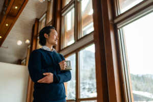 man enjoying a cofee in the otter hotel event space with vaulted ceilings