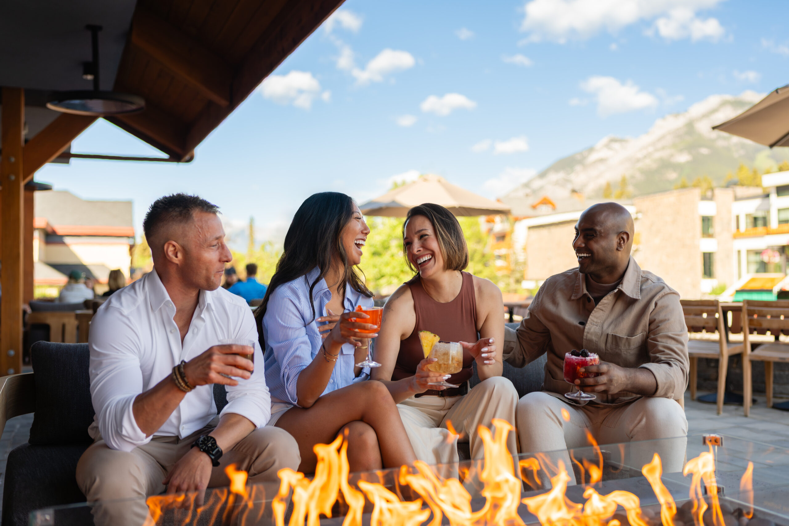 Good Folk Patio Two couples enjoying cocktails on Good Folk's patio in front of a fire pit.