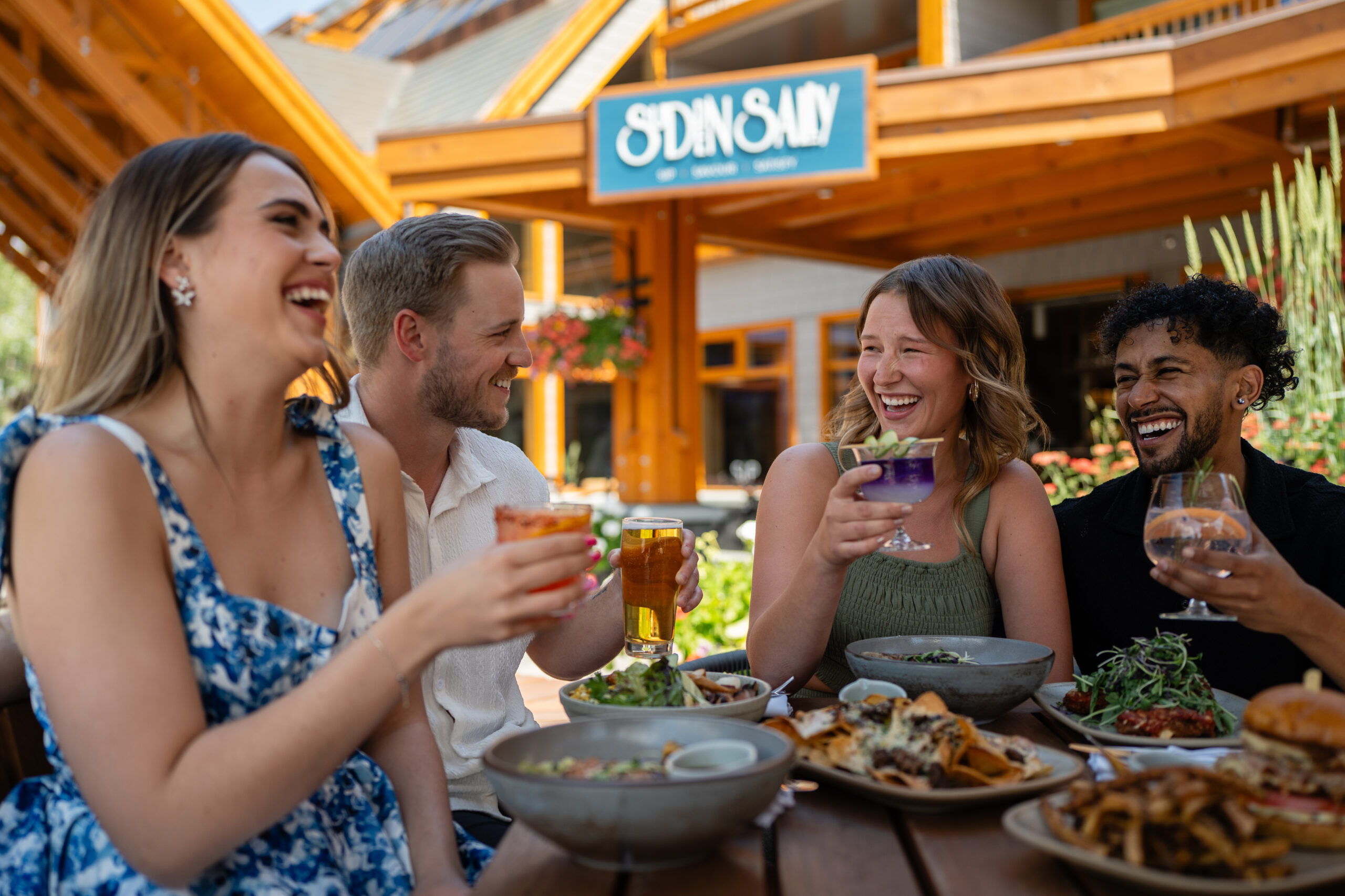 Sudden.Sally.Patio Two couples enjoying food and cocktails on the Sudden Sally patio in Banff