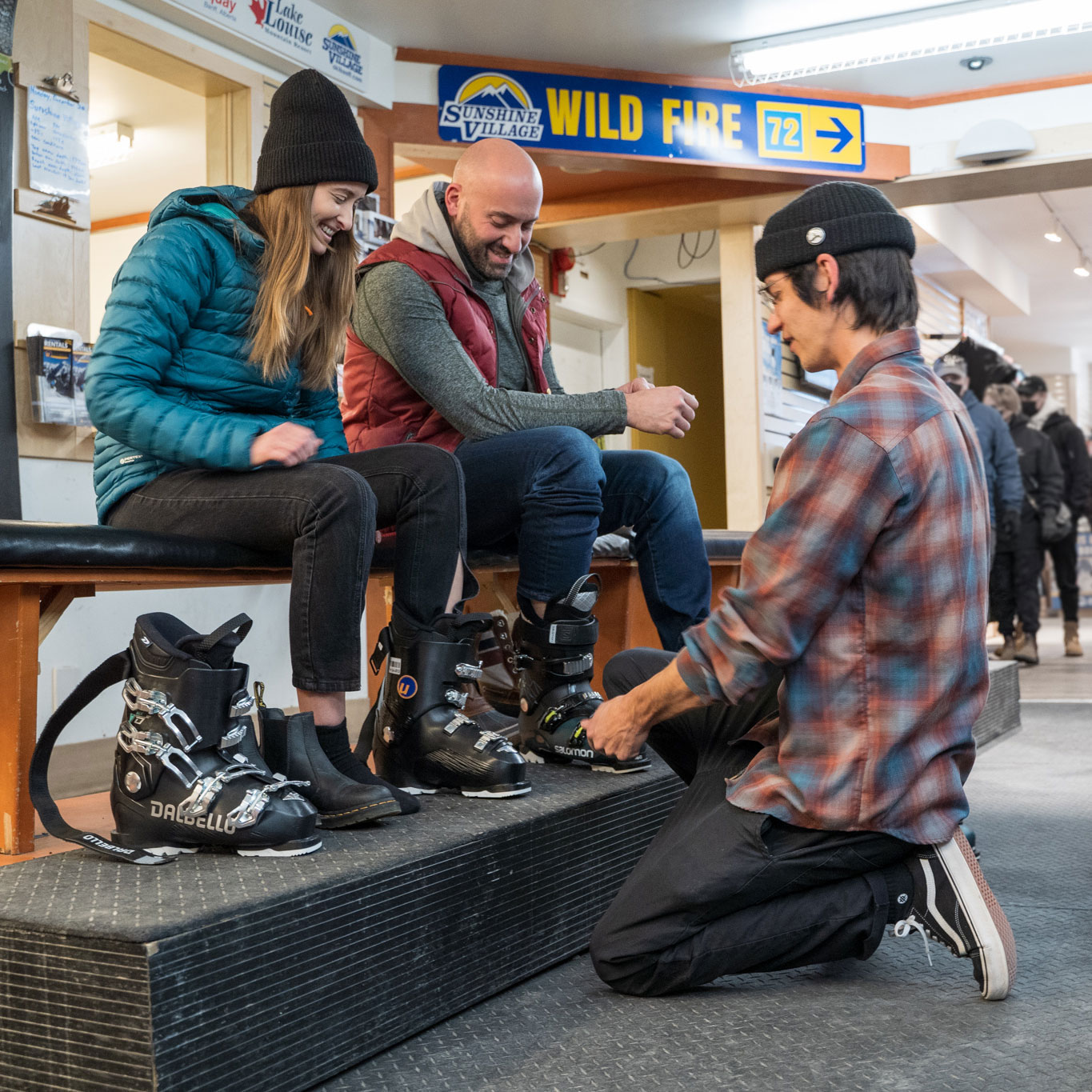 Sports store expert helping couple find rental ski boots