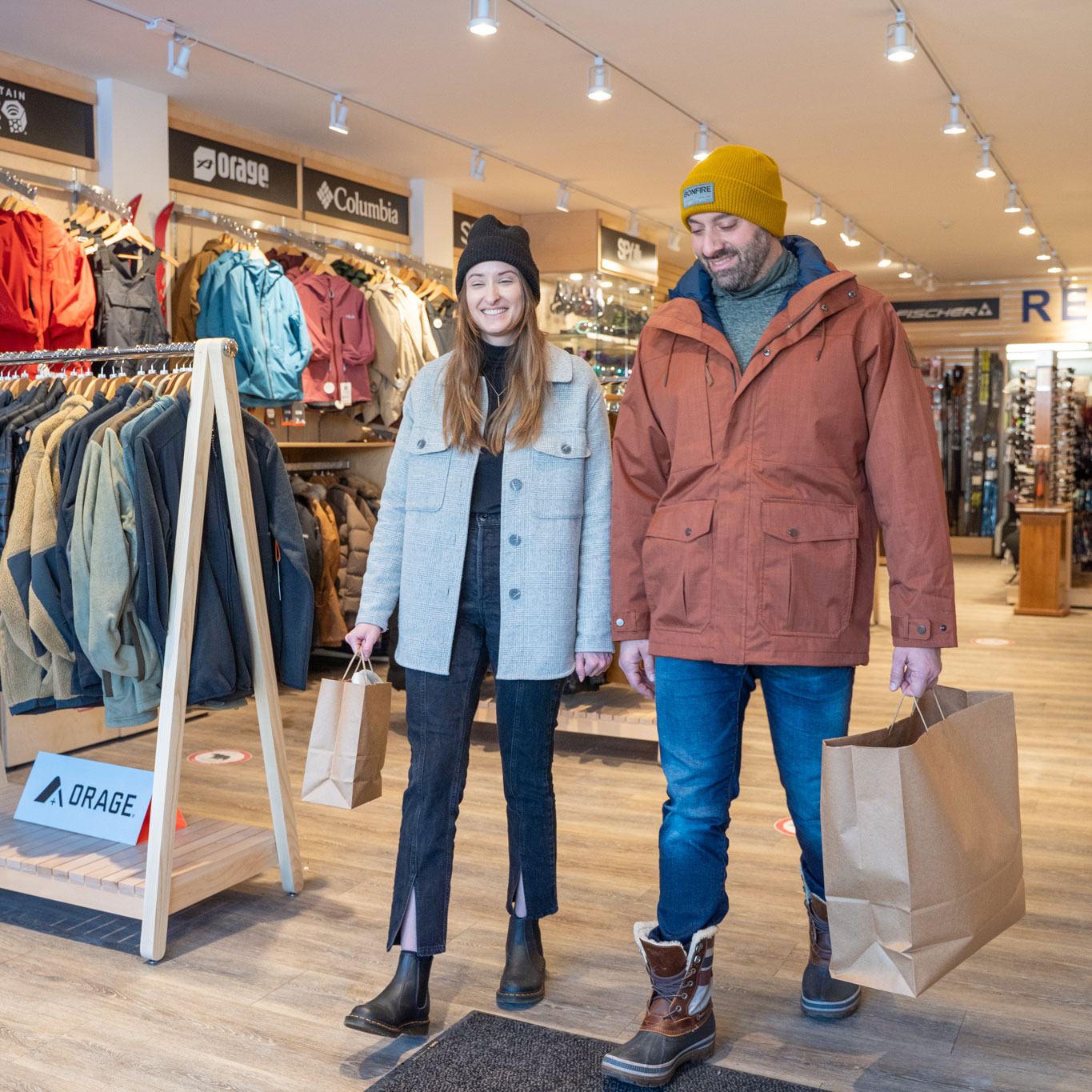 Couple shopping at sports store leaving with purchase